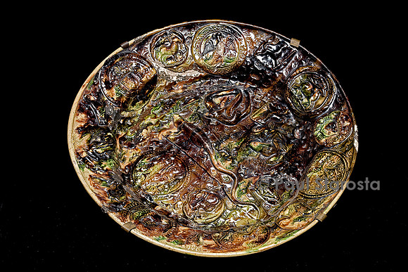Plat rond estampé en terre cuite, glaçure plombifère sur fond jaspé brun, jaune avec lézard central